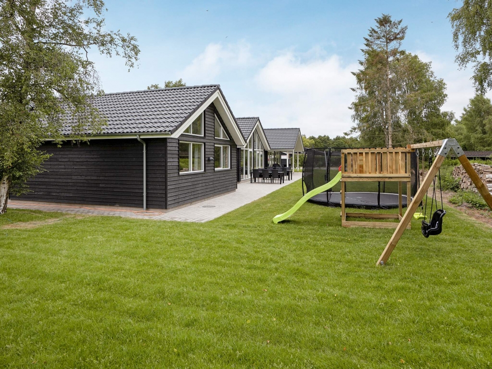I det attraktive aktivitesrum i luksushus nr. 543 i Lolland/Falster/Møn  er der masser af udendørs aktiviteter, f.eks. legetårn og gynge