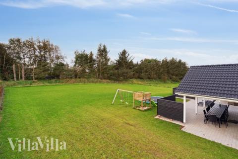 I det attraktive aktivitesrum i luksushus nr. 545 i Limfjorden  er der masser af udendørs aktiviteter, f.eks. legetårn og gynge