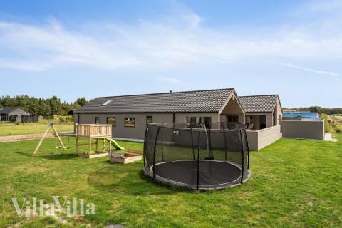 I det attraktive aktivitesrum i luksushus nr. 560 i Vestjylland  er der masser af udendørs aktiviteter, f.eks. legetårn og gynge