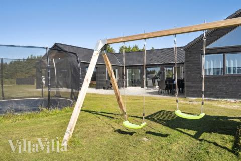 I det attraktive aktivitesrum i luksushus nr. 583 i Vestjylland  er der masser af udendørs aktiviteter, f.eks. legetårn og gynge