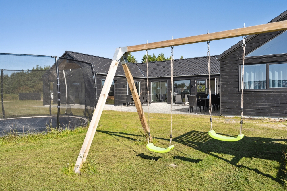 I det attraktive aktivitesrum i luksushus nr. 583 i Vestjylland  er der masser af udendørs aktiviteter, f.eks. legetårn og gynge