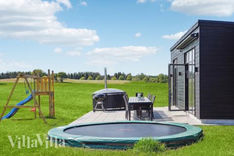 I det attraktive aktivitesrum i luksushus nr. 604 i Østjylland  er der masser af udendørs aktiviteter, f.eks. legetårn og gynge