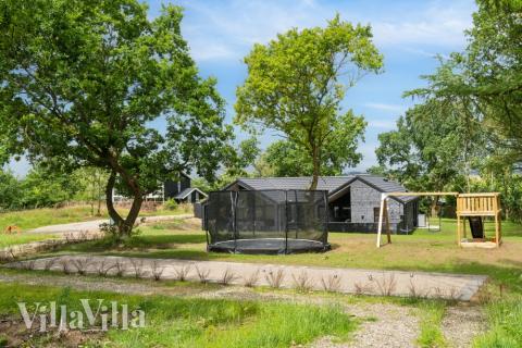 I det attraktive aktivitesrum i luksushus nr. 640 i Østjylland  er der masser af udendørs aktiviteter, f.eks. legetårn og gynge