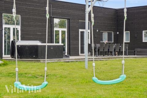 I det attraktive aktivitesrum i luksushus nr. 642 i Lolland/Falster/Møn  er der masser af udendørs aktiviteter, f.eks. legetårn og gynge