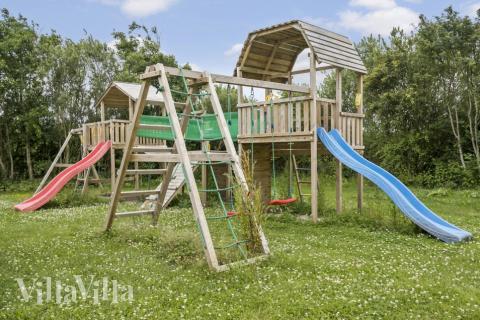 I det attraktive aktivitesrum i luksushus nr. 677 i Vestjylland  er der masser af udendørs aktiviteter, f.eks. legetårn og gynge