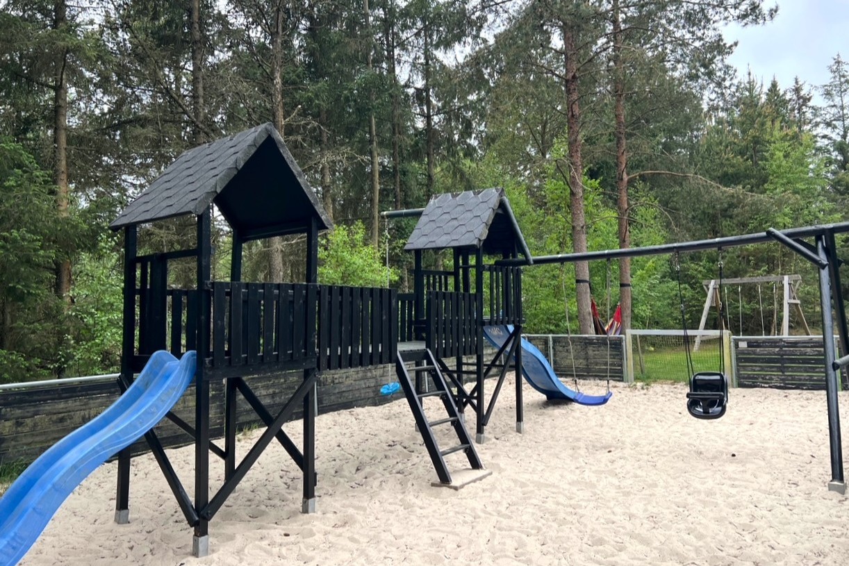I det attraktive aktivitesrum i luksushus nr. 197 i Vestjylland  er der masser af udendørs aktiviteter, f.eks. legetårn og gynge