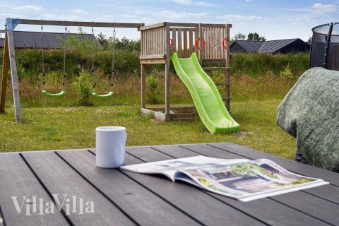 I det attraktive aktivitesrum i luksushus nr. 619 i Nordjylland  er der masser af udendørs aktiviteter, f.eks. legetårn og gynge