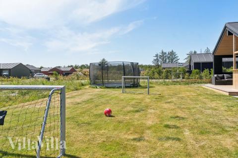 I det attraktive aktivitesrum i luksushus nr. 656 i Nordjylland  er der masser af udendørs aktiviteter, f.eks. legetårn og gynge