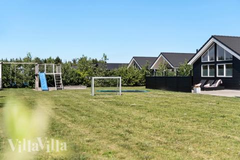 I det attraktive aktivitesrum i luksushus nr. 475 i Vestjylland  er der masser af udendørs aktiviteter, f.eks. legetårn og gynge