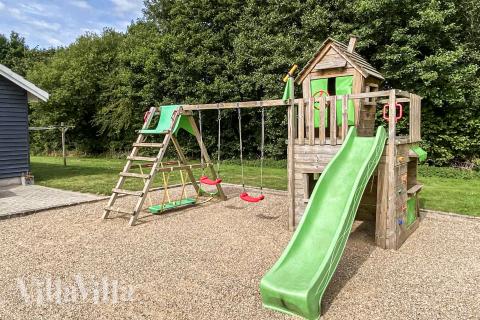 I det attraktive aktivitesrum i luksushus nr. 281 i Sydjylland  er der masser af udendørs aktiviteter, f.eks. legetårn og gynge