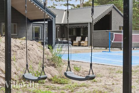 I det attraktive aktivitesrum i luksushus nr. 697 i Lolland/Falster/Møn  er der masser af udendørs aktiviteter, f.eks. legetårn og gynge