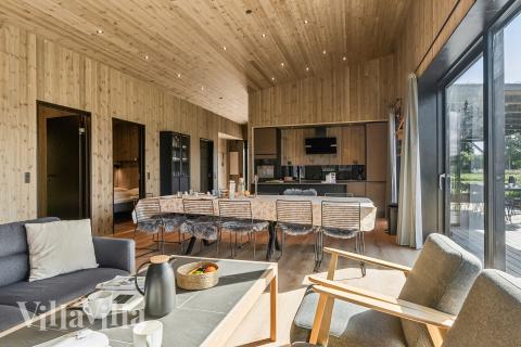 I kan sagtens side 12 personer sammen i sommerhusets opholdsrum, når I besøger luksushus 925 i Limfjorden.