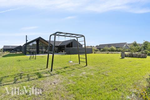 I det attraktive aktivitesrum i luksushus nr. 698 i Vestjylland  er der masser af udendørs aktiviteter, f.eks. legetårn og gynge