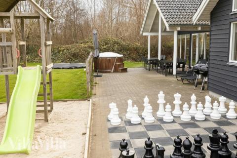 I det attraktive aktivitesrum i luksushus nr. 255 i Sydjylland  er der masser af udendørs aktiviteter, f.eks. legetårn og gynge